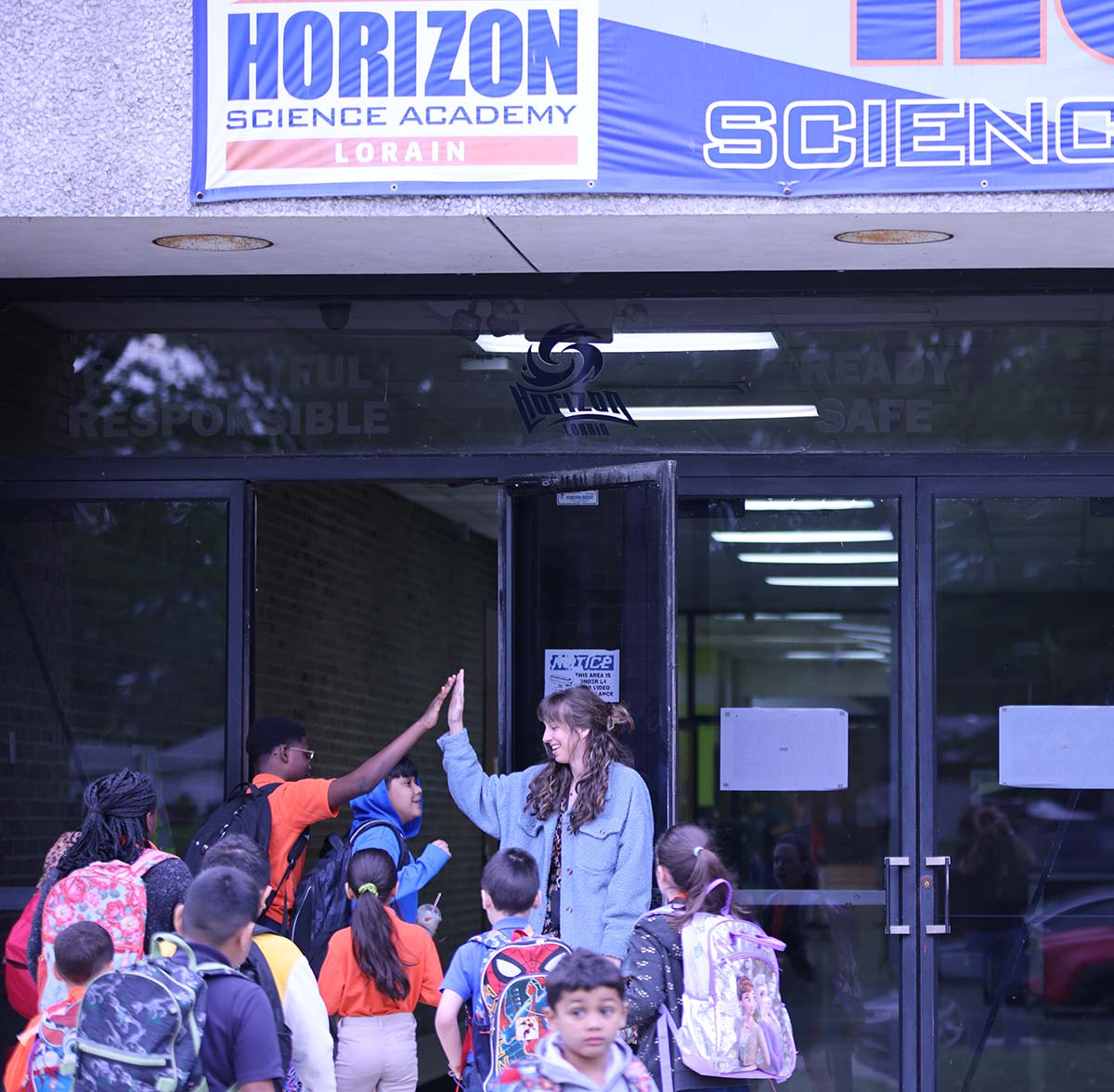 HSA Lorain South Teacher and student interacting at a classroom desk
