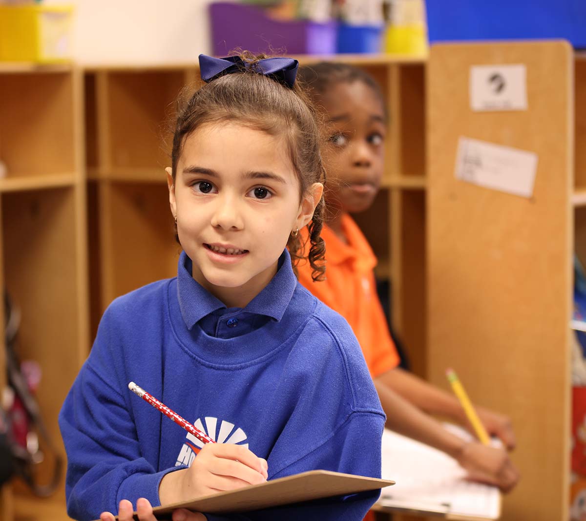 Student working on a notebook in a classroom.